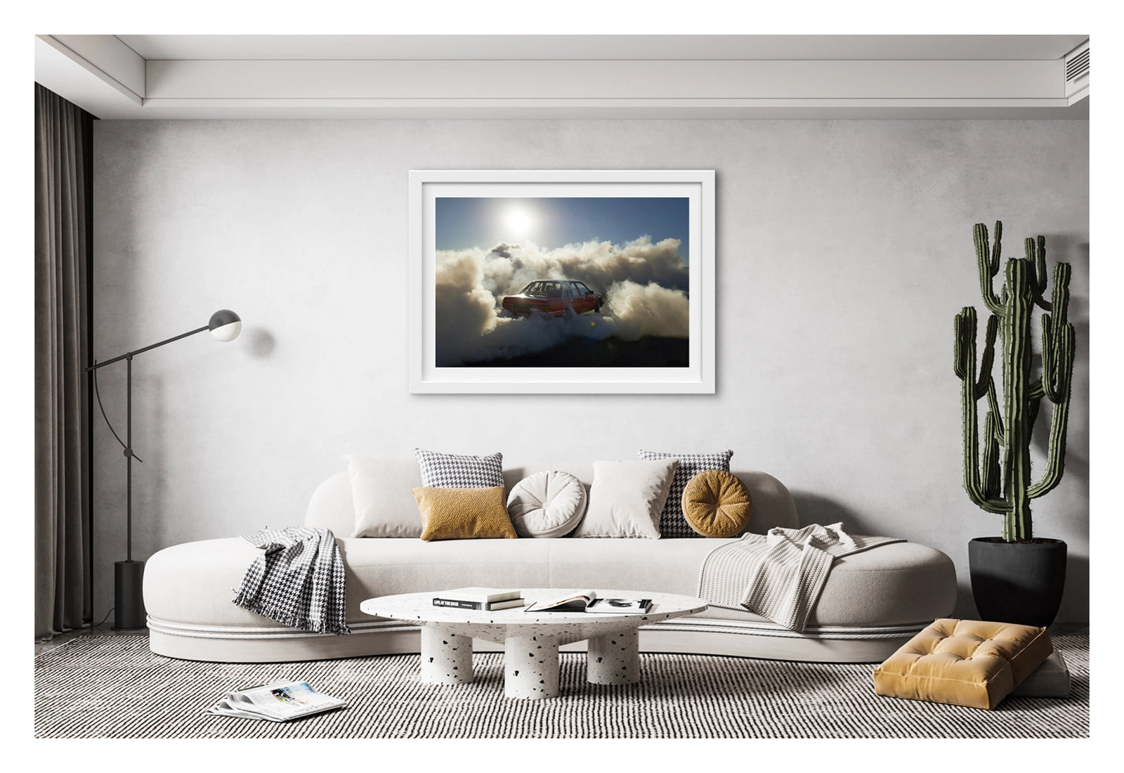 Framed in white, hanging in a contemporary space. A red Holden Commodore sedan performs a burnout under a blazing sun, backlit by the harsh white glare as thick white tyre smoke billows outward in every direction and glows gold where the sunlight cuts through. The stripped interior and roll cage are visible through the rear window as the car sits deep in its own cloud, the brilliant sun and deep blue central Australian sky burning above the chaos below. Fine art colour photographic print by Simon Davidson.