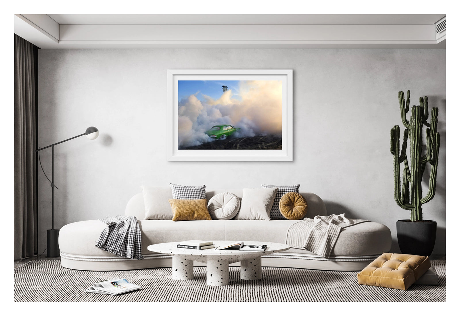Framed in white, hanging in living space. We see a green Holden LJ Torana sedan performing a burnout, slightly engulfed against a towering wall of white and golden tyre smoke that billows up toward a deep blue sky. Stadium flood lights pierce the haze above as the smoke catches the warm evening light, the bright green body of the car vivid against the swirling white cloud and the rubber marked black bitumen below. Fine art colour photographic print by Simon Davidson.