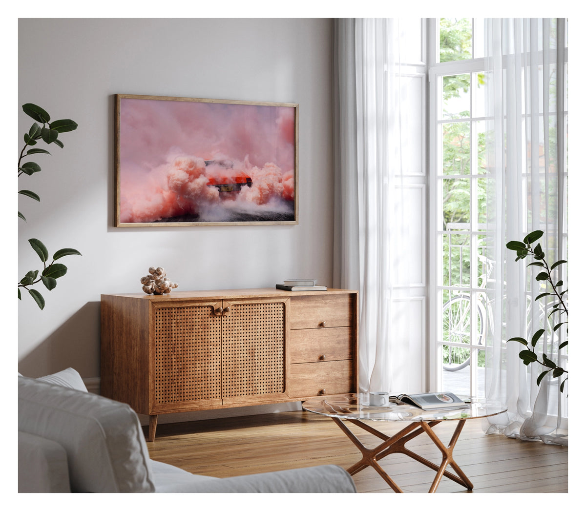 Framed in timber, shown in a contemporary living scene. We see a orange Holden sedan bearing the number plate LITMUP performing a burnout, the car almost entirely consumed by the vast churning cloud of pink/orange tyre smoke that fills the whole frame. The roofline and rear window are just visible through the enveloping haze as pink smoke billows in every direction across the velvety black bitumen below. Fine art colour photographic print by Simon Davidson.