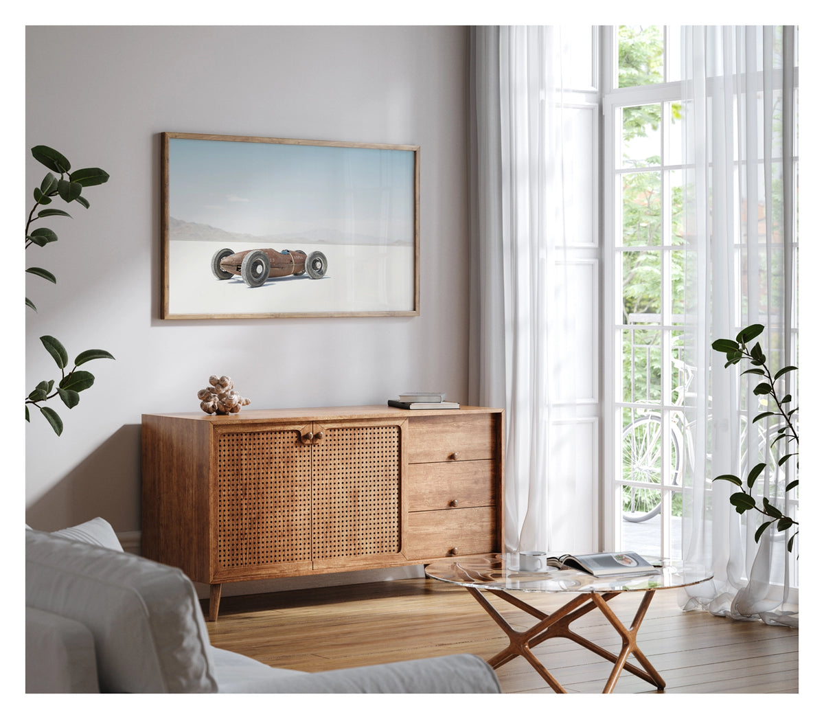 Framed in timber. A small rust patinated vintage bellytanker landspeed race car sits alone on the blinding white salt of the Bonneville Salt Flats, its exposed wire wheels and torpedo shaped body giving it the appearance of a miniature prewar racing car. A hazy mountain range dissolves into the pale horizon behind it under a soft blue sky, the tiny machine dwarfed by the vast emptiness surrounding it. Fine art colour photographic print by Simon Davidson.