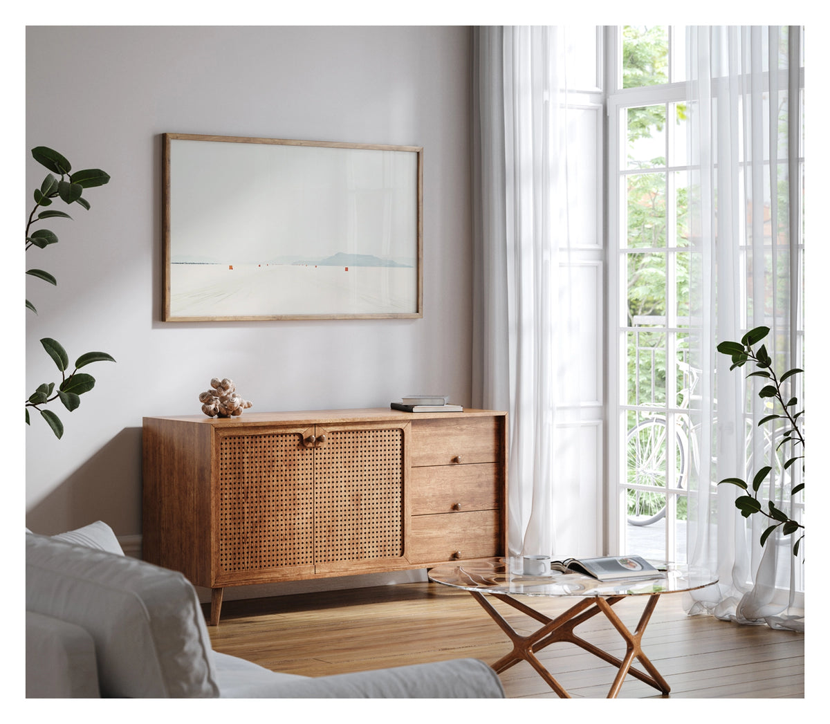 Framed in timber, shown in a contemporary living space. We see a row of small orange course markers stretches into the vanishing point across the blinding white surface of the Bonneville Salt Flats, tyre tracks scoring the salt in the foreground as distant mountains dissolve into a pale grey horizon. The vast emptiness of the scene and the near seamless merging of salt flat and sky give the image a stark, minimalist beauty. Fine art colour photographic print by Simon Davidson.