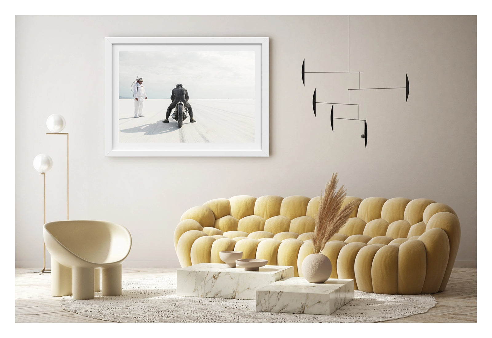 Framed in white hanging in a contemporary living space. Motorcycle racer Shinya Kimura in black leathers crouches low over his vintage custom motorcycle on the Bonneville Salt Flats, poised at the start of a run as tyre tracks stretch toward the vanishing point ahead. A race official in a white jumpsuit and radio headset stands to the left watching on, the vast white salt and pale overcast sky dissolving into a seamless horizon in the distance. Fine art colour photographic print by Simon Davidson.