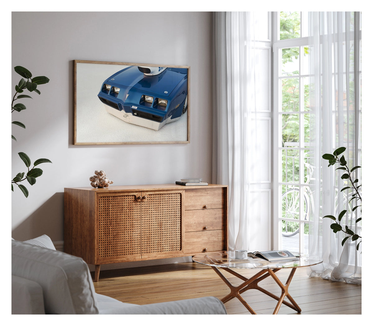 Framed in timber, hanging in a contemporary living space. We see a close up of the front end of a blue Pontiac Trans Am land speed racer sitting low on the white salt of the Bonneville Salt Flats, its distinctive quad headlights, Pontiac arrow nose and fabricated aluminium lower valance filling the frame. A streamliner style intake is visible above the bonnet line, the deep blue paint and salt crusted surface contrasting sharply in the crisp flat light. Fine art colour photographic print by Simon Davidson.