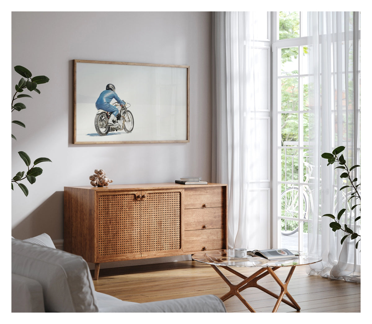Framed in timber, hanging in a contemporary living space. An image of a  lone motorcycle racer dressed in a blue leather suit and silver helmet rides a vintage Triumph, land speed racing motorcycle across the blinding white expanse of the Bonneville salt flats, the rider and bike reduced to a small solitary figure against an almost entirely white horizon and washed out sky. Shown in a contemporary living room. Fine art colour photographic print by Simon Davidson.
