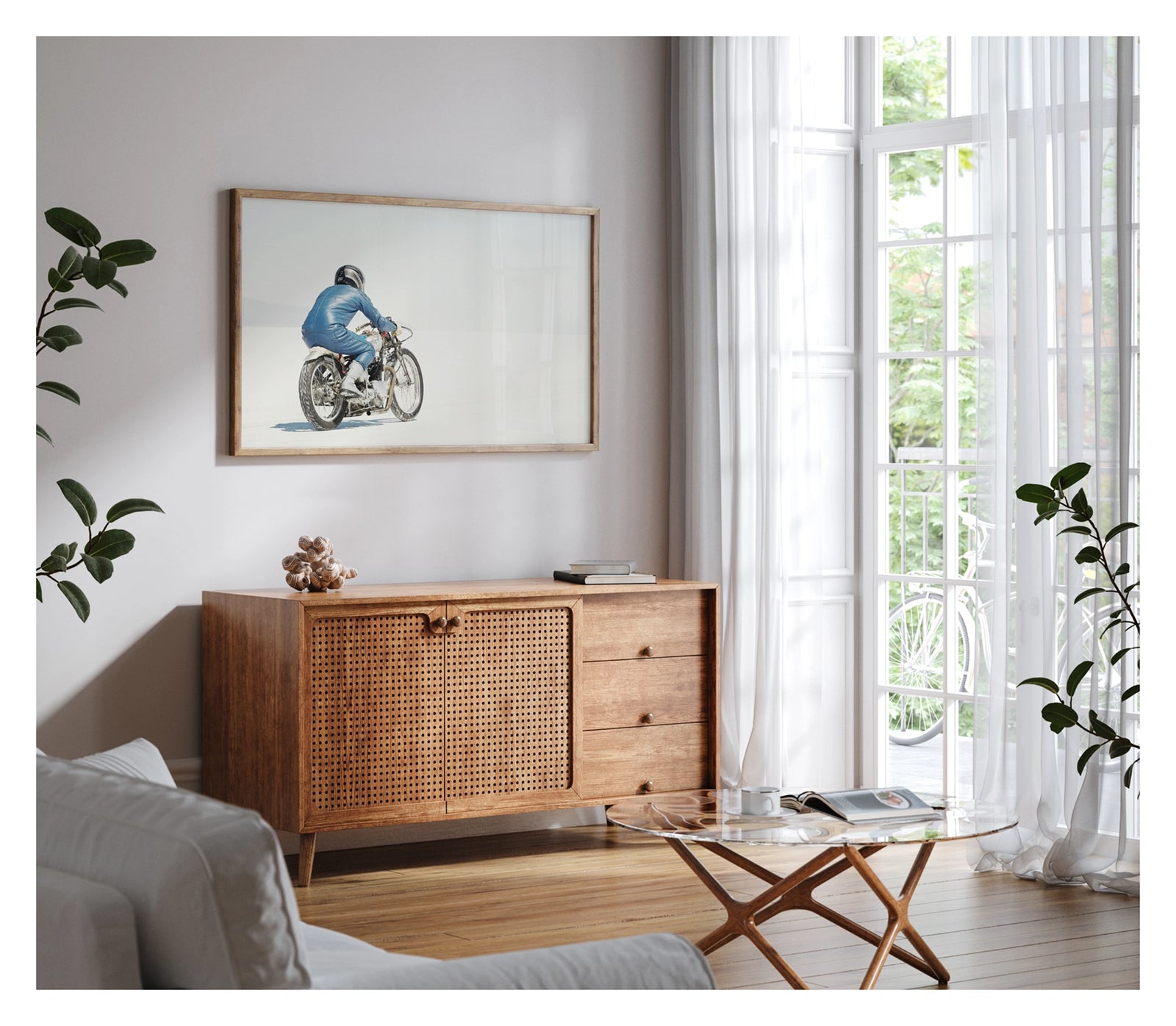 Framed in timber, hanging in a contemporary living space. An image of a  lone motorcycle racer dressed in a blue leather suit and silver helmet rides a vintage Triumph, land speed racing motorcycle across the blinding white expanse of the Bonneville salt flats, the rider and bike reduced to a small solitary figure against an almost entirely white horizon and washed out sky. Shown in a contemporary living room. Fine art colour photographic print by Simon Davidson.