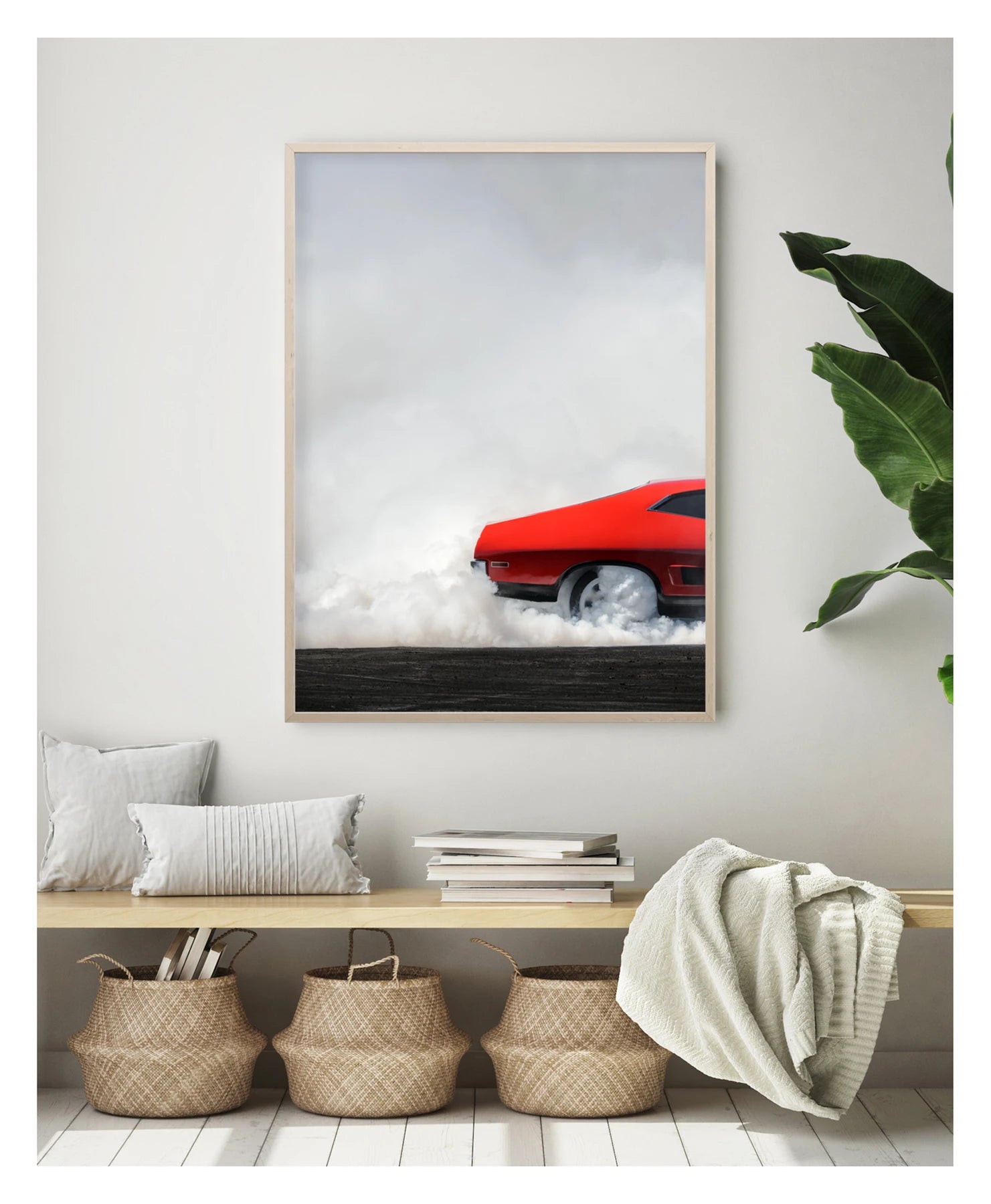 Framed in timber in a portrait orientation. A red Ford Falcon XB coupe performs a burnout, shown is the back half of the car with dense white tyre smoke pouring from the rear wheels and engulfing the lower half of the car against a white smoke filled sky. The bold red bodywork and fastback roofline sit in sharp contrast to the billowing white smoke rolling across the scorched black bitumen below. Shown in a contemporary room. Fine art colour photographic print by Simon Davidson.