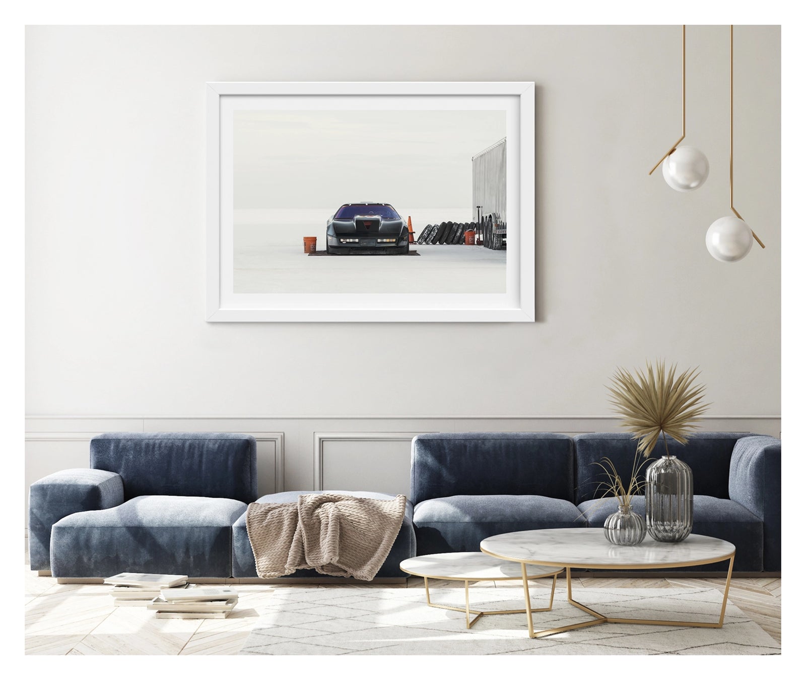 Framed in white and shown in a contemporary space. A black Chevrolet Corvette land speed racing car sits low on a ground sheet in the pits at Bonneville. Surrounded by the vast white expanse of the Salt Flats, faced directly toward the camera. Orange buckets, a row of spare tyres leaning against a trailer and an orange traffic cone are scattered around the pit area to the right, the whole scene dissolving into a featureless white horizon and sky. Fine art colour photographic print by Simon Davidson.