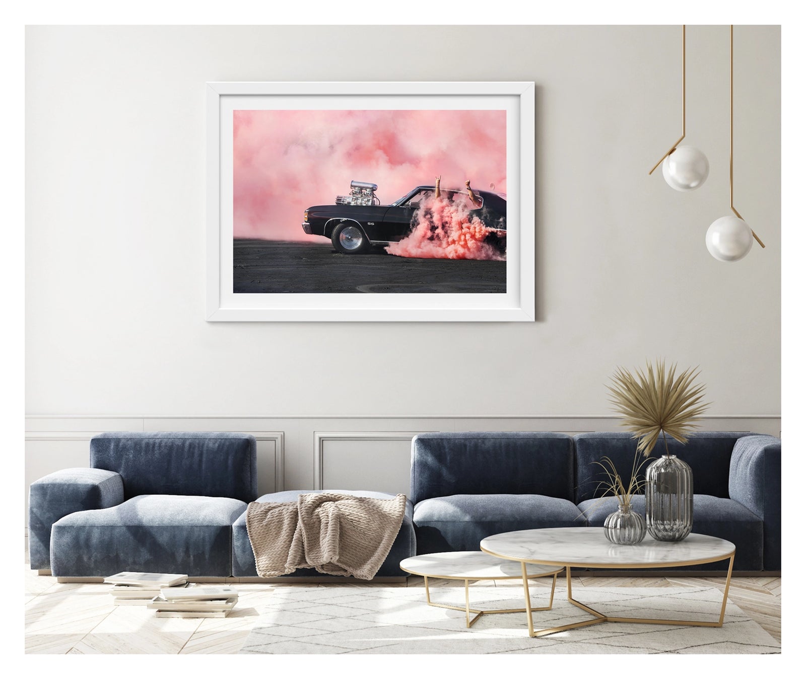 Framed in white, hanging in a contemporary living space. We see a black Chevrolet Chevelle SS with a massive polished supercharger protruding through the bonnet performs a burnout, engulfed in vivid pink tyre smoke that fills the entire background. The chrome blower and intake manifold gleam against the dark body as thick pink smoke pours from the under the car onto the tyre marked scorched black bitumen. Passengers'  arms out the windows in celebration. Fine art colour photographic print by Simon Davidson.