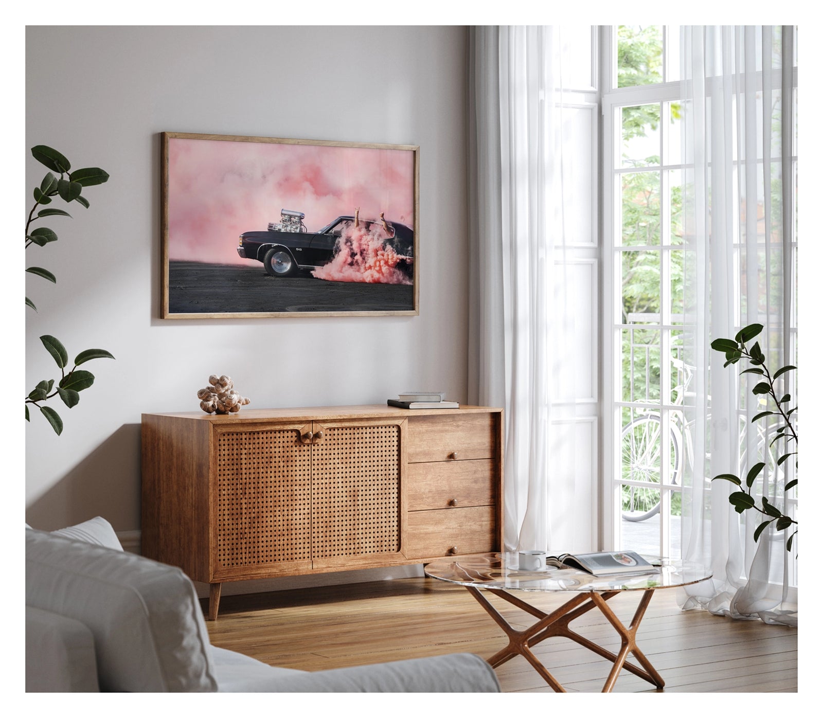 Framed in timber, hanging in a contemporary living space. We see a black Chevrolet Chevelle SS with a massive polished supercharger protruding through the bonnet performs a burnout, engulfed in vivid pink tyre smoke that fills the entire background. The chrome blower and intake manifold gleam against the dark body as thick pink smoke pours from the under the car onto the tyre marked scorched black bitumen. Passengers'  arms out the windows in celebration. Fine art colour photographic print by Simon Davidson
