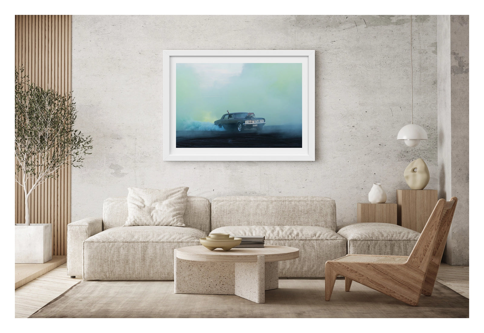 Framed in white, shown in a contemporary living space. A black Holden HD sedan with a supercharger out the bonnet, bearing the number plate UCSMOKE, performs a burnout surrounded by vast aquamarine tyre smoke that bathes the entire scene in soft blue green light. A driver's arm reaches out the window above the roofline, as aqua smoke rolls low across the ground and the ethereal coloured haze fills the sky behind. Fine art colour photographic print by Simon Davidson.