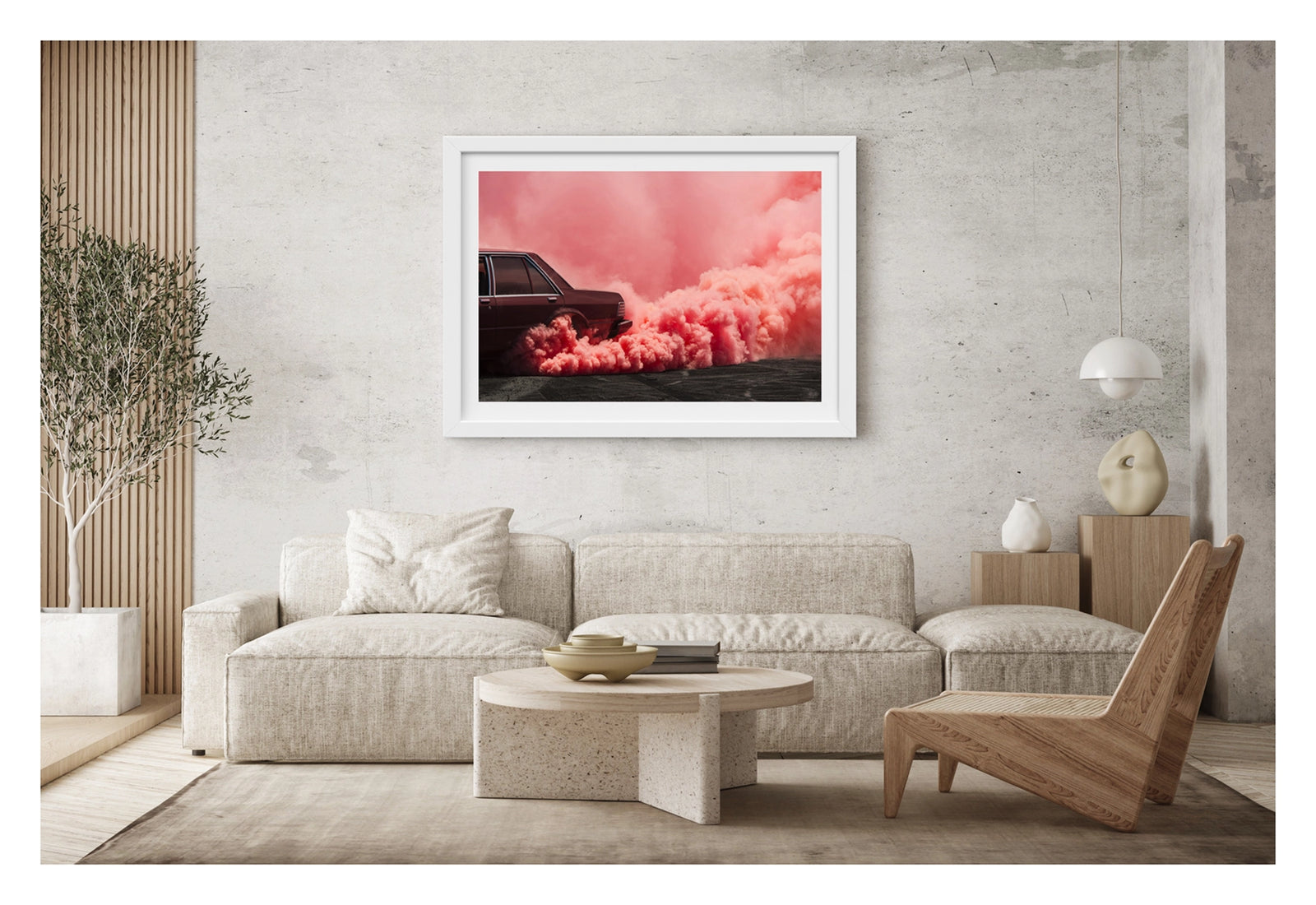 Framed in white, shown in a contemporary living space. The visible rear lefthand quarter of a dark burgundy Ford Falcon sedan is mid burnout, a massive rolling cloud of vivid pink tyre smoke erupting from the rear wheel arch and sweeping across the full width of the frame. The deep red body of the car sits in rich tonal harmony with the warm pink smoke that floods the sky above and rolls heavily across the tyre marked burnout pad. Fine art colour photographic print by Simon Davidson. 
